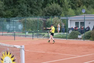 Blick über das Netz auf einen Spieler im Ballwechsel