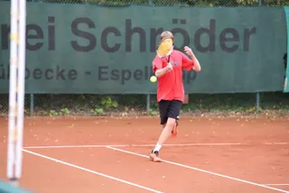 Ein Junge im roten Trikot spielt den Ball