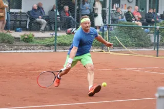 Ein Spieler im blauen Trikot beim Rückhandschlag