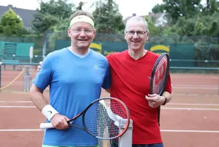 Zwei Spieler mit Stirnband und Schlägern auf dem Platz