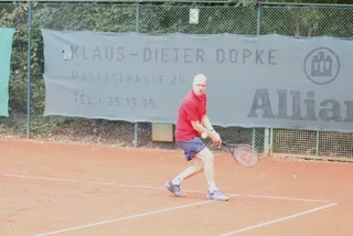 Ein Spieler an der Grundlinie vor der Werbebande