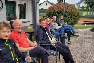 Mitglieder sitzen unter dem Terrassendach zusammen