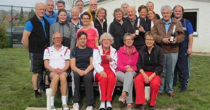 Mitglieder beim Anspielen vor dem Vereinsheim, in der Mitte ein Pokal