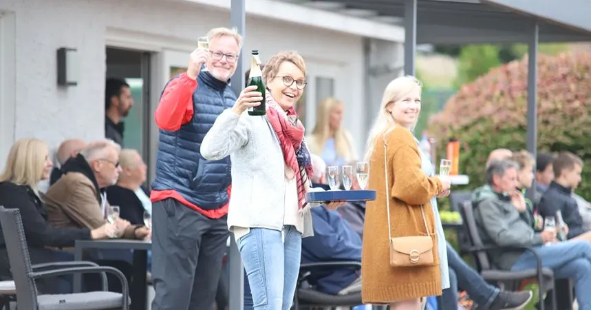 Mitglieder mit Getränken auf der Terrasse des Vereinsheims