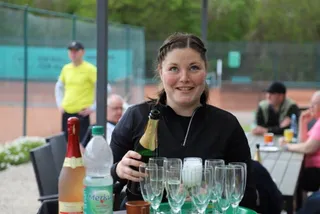 Ein Mitglied schenkt Sekt für die Runde ein
