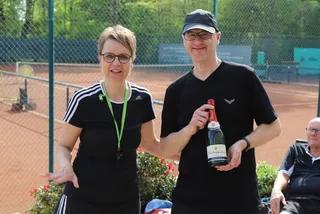 Zwei Mitglieder mit Sekt vor den Plätzen