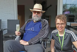 Zwei Mitglieder auf der Terrasse, eines mit einem Glas Sekt