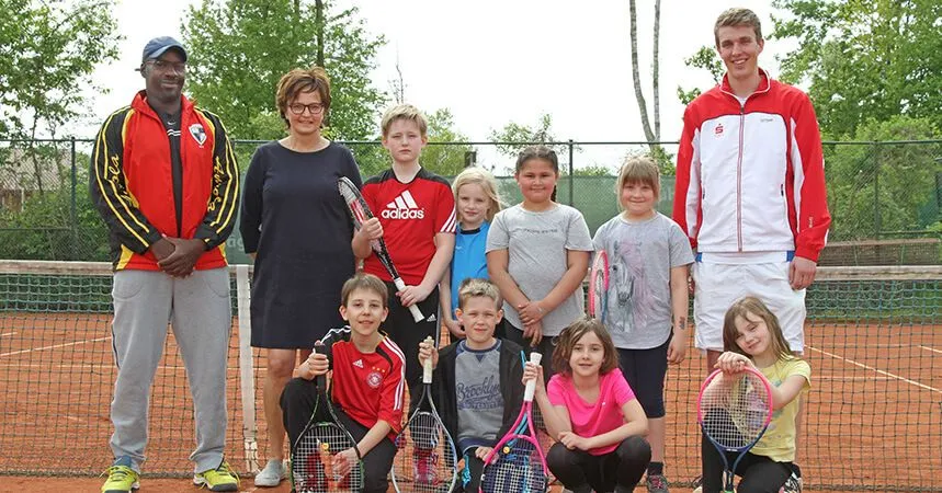 Der neue Trainer mit den Kindern auf dem Platz